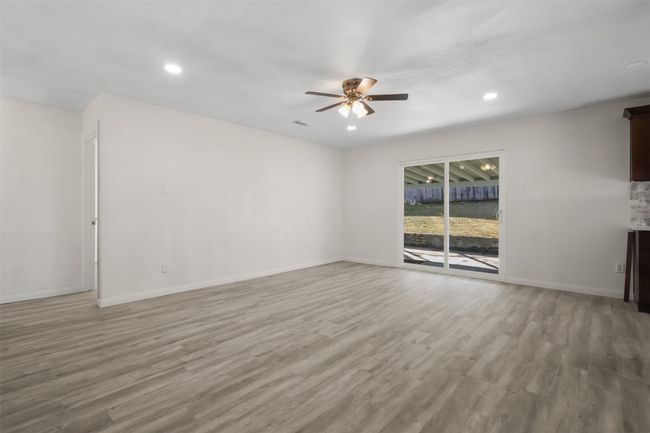 Unfurnished living room with ceiling fan and light wood-type flooring | Image 14