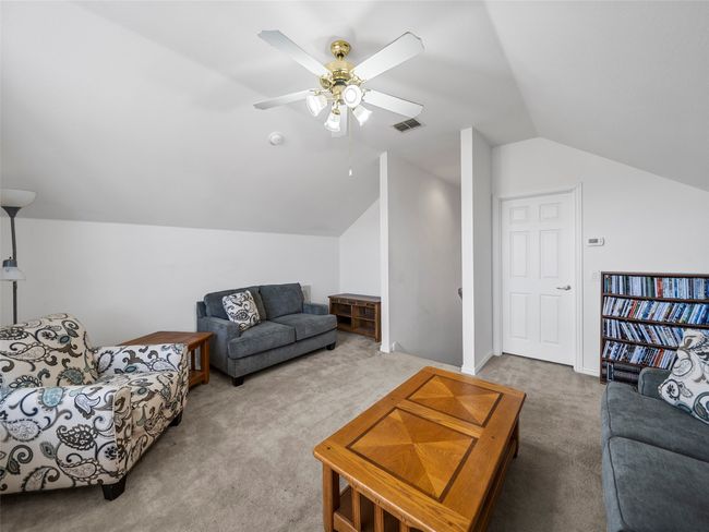 Living area with a ceiling fan, carpet flooring, vaulted ceiling, and visible vents | Image 27