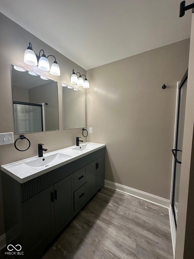 Unit 2 - full bath with double vanity, wood finished floors, and a shower with shower door | Image 23