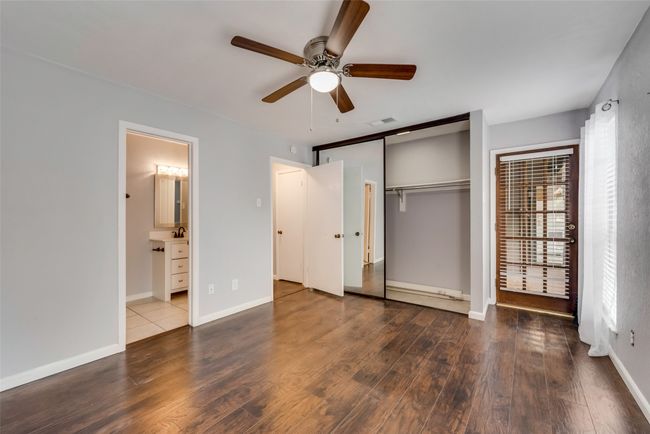 Unfurnished bedroom with wood finished floors, a closet, a ceiling fan, and connected bathroom | Image 13
