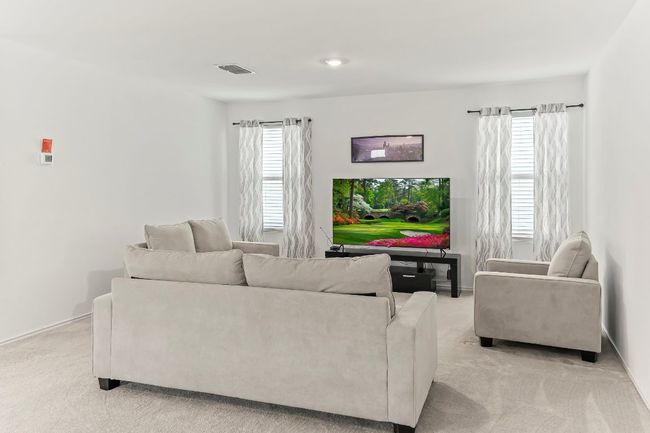 Living area featuring light carpet and baseboards | Image 7