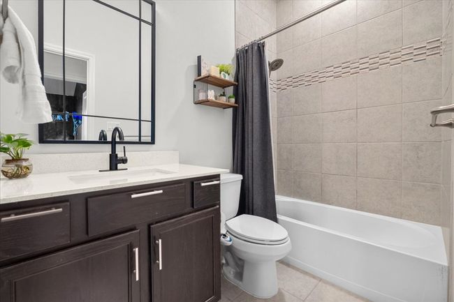 Bathroom with toilet, vanity, shower / tub combo with curtain, and tile patterned floors | Image 29