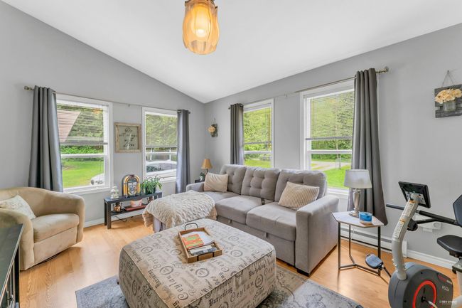 Living area featuring lofted ceiling and light wood-style floors | Image 23