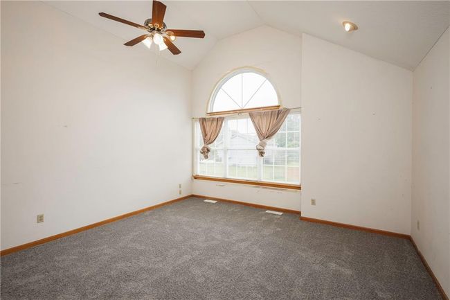 Carpeted empty room featuring ceiling fan, high vaulted ceiling, and baseboards | Image 17
