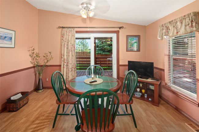Dining space with wood finished floors & door to deck | Image 19
