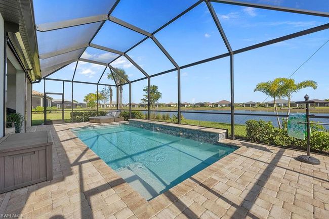 Pool with glass enclosure, a patio, and a water view | Image 40