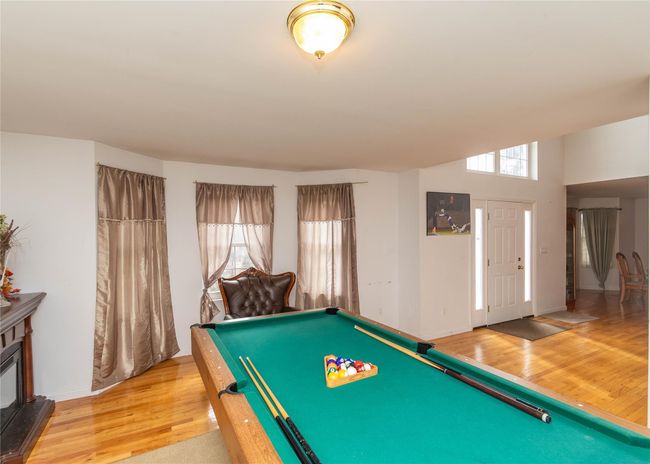 Rec room featuring light wood finished floors, baseboards, billiards, and a wealth of natural light | Image 12