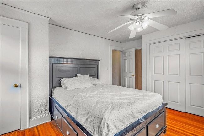 Bedroom featuring a textured ceiling, a closet, ceiling fan, and light hardwood / wood-style floors | Image 35