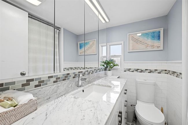 Bathroom featuring vanity, tile walls, toilet, and wainscoting | Image 8