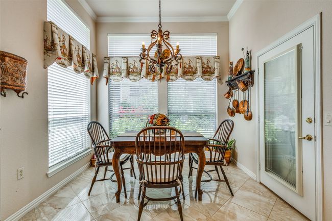 Dining area with a chandelier, crown molding, and light marble finish flooring | Image 13