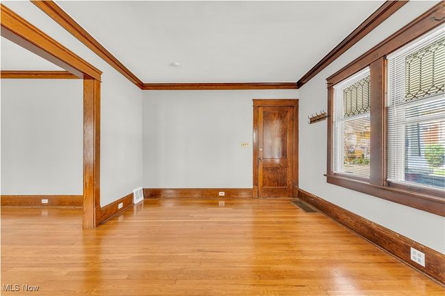 Empty room with visible vents, crown molding, light wood-style flooring, and baseboards | Image 6