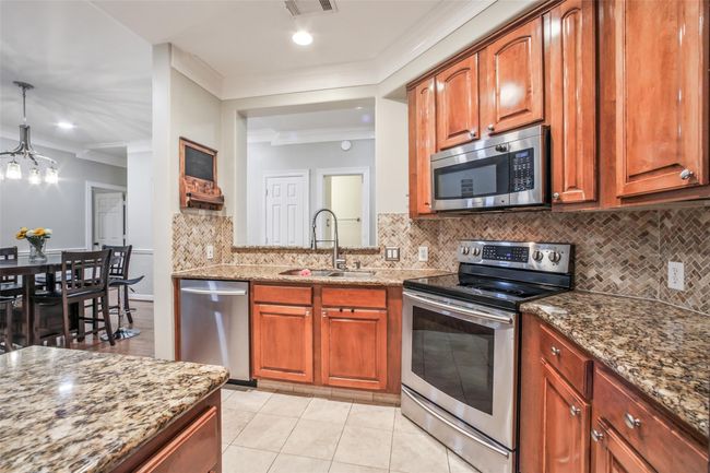 Spacious kitchen features granite countertops and stainlesss appliances. | Image 9