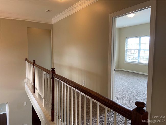 Open railing on upper level overlooking stairs, and foyer. Primary bedroom is at the end of the hallway. | Image 14