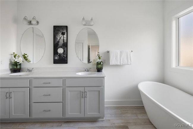 Luxurious primary bath with double vanity, soaking tub, and spa-inspired design. | Image 24