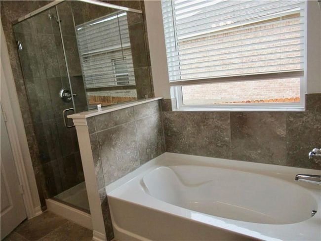 Bathroom featuring a bath and a stall shower | Image 13