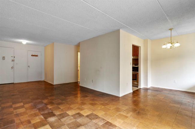Empty room with a chandelier and a textured ceiling | Image 11