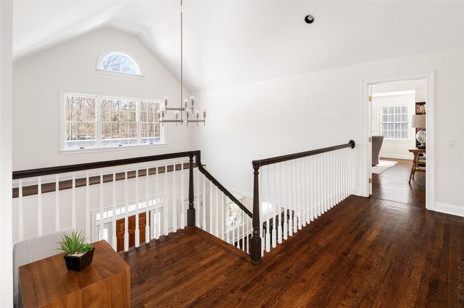 Second floor landing with lofted ceiling, chandelier, dark hardwood finished floors. | Image 17