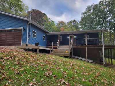 Rear view of property with a wooden deck and a garage | Image 1