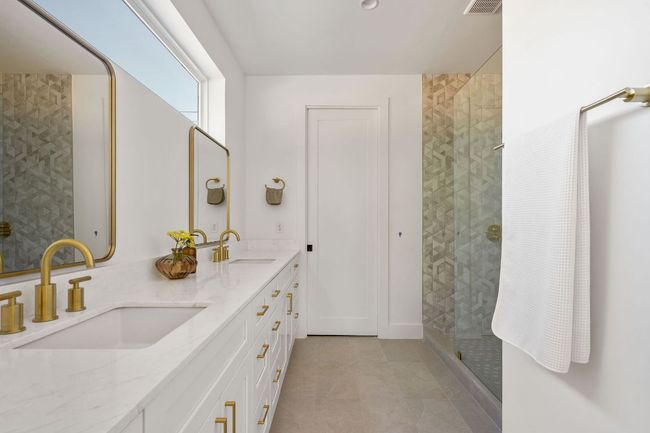 Bathroom with a sink, visible vents, a tile shower, and double vanity | Image 35