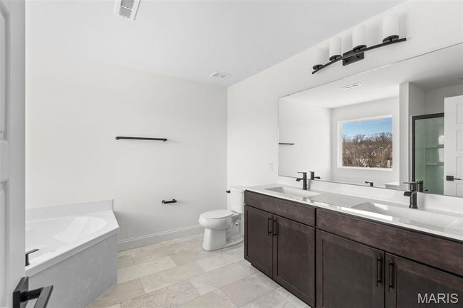 Bathroom with a bath, double vanity, and an enclosed shower | Image 5