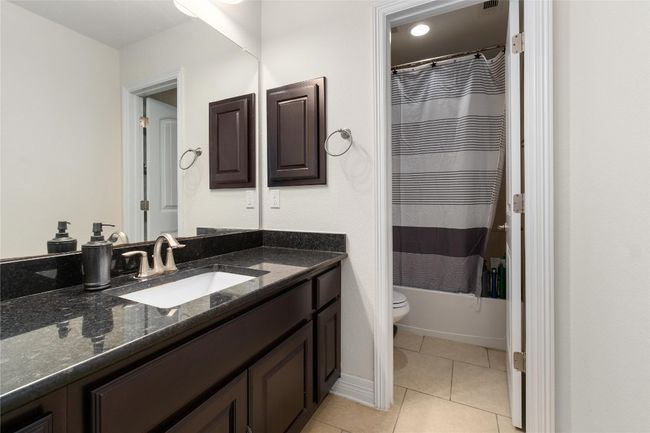 Full bath featuring tile patterned floors, shower / tub combo, toilet, and vanity | Image 27