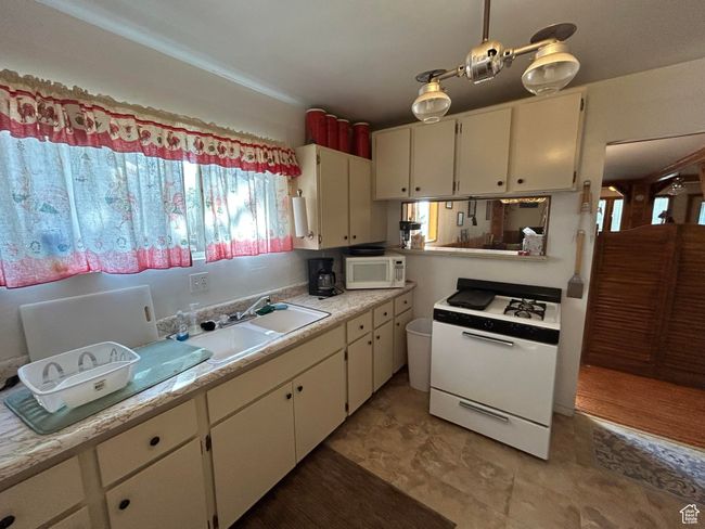 Kitchen featuring white appliances, light countertops, and white cabinets | Image 13