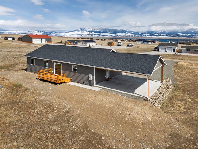 Back of house featuring an attached carport, roof with shingles, and a deck with mountain view | Image 5