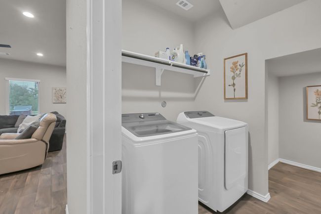 The laundry space sits next to the stairway downstairs, perfectly positioned for easy access for all. Notice that there is an entire storage room off of the laundry that tucks underneath the stairs giving you BONUS storage space. | Image 31