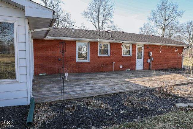 rear view of property featuring a wooden deck, brick siding, and roof with shingles | Image 36