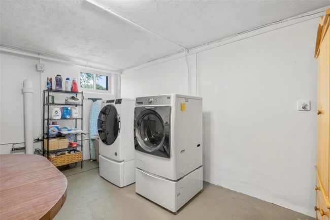 Laundry room featuring washing machine and clothes dryer and a textured ceiling | Image 20