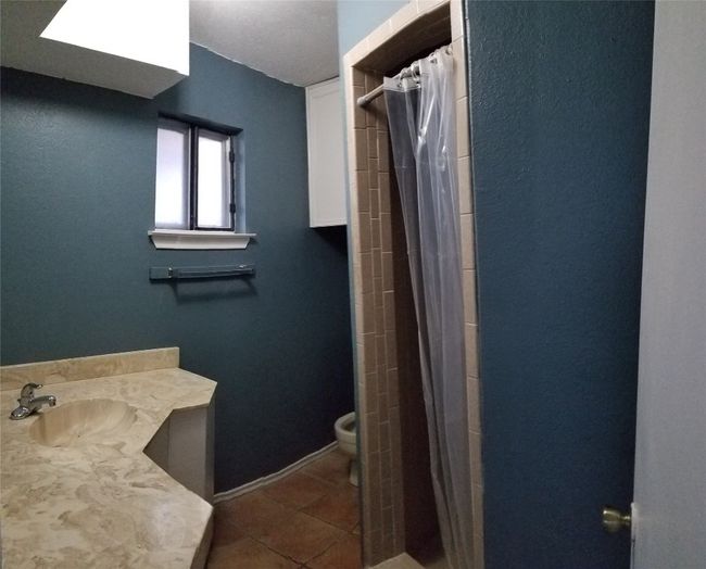 Full bath with a sink, tile patterned floors, toilet, a shower with shower curtain, and baseboards | Image 10
