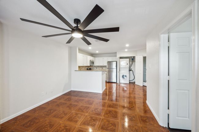 Open living concept with a ceiling fan, recessed lighting, baseboards, and stacked washer and clothes dryer | Image 15