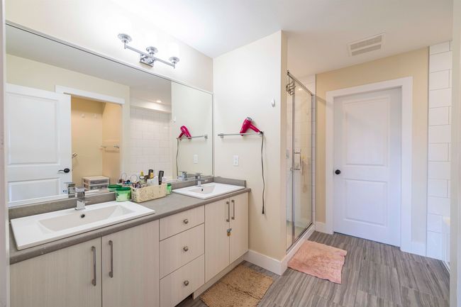 Bathroom featuring double vanity, visible vents, a shower stall, and a sink | Image 15