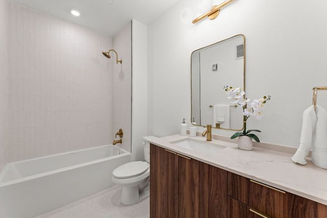Bathroom with toilet, vanity, shower / tub combination, and visible vents | Image 10