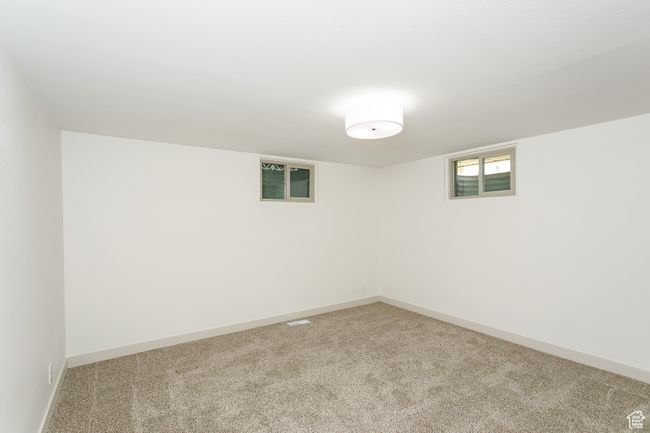 Below grade area featuring light carpet and baseboards | Image 8