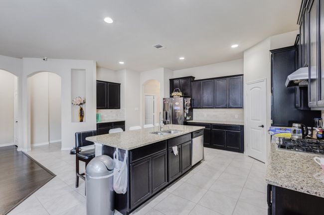 Kitchen with arched walkways, appliances with stainless steel finishes, a sink, tasteful backsplash, and recessed lighting | Image 13