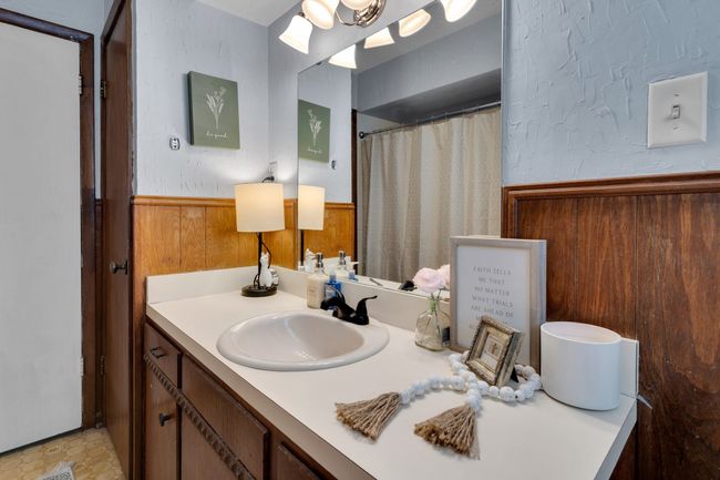 Full bathroom featuring vanity, a wainscoted wall, and a shower with curtain | Image 17