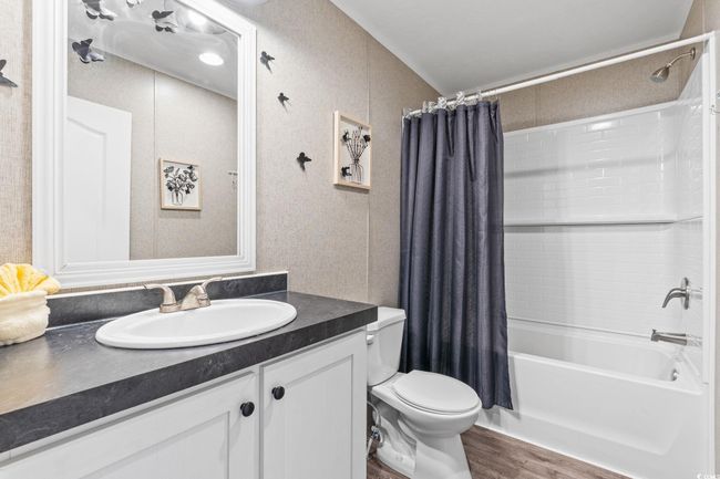Bathroom with vanity, shower / bath combo with shower curtain, toilet, and wood finished floors | Image 24