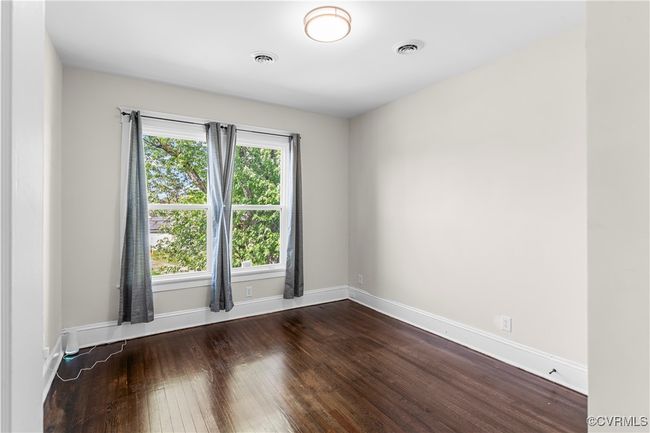 Unfurnished room featuring dark wood finished floors, visible vents, and baseboards | Image 27