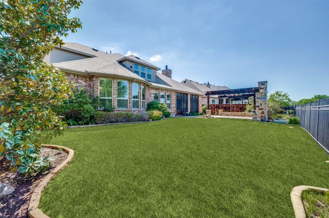 The large yard, surrounded by lush landscaping, offers plenty of space for kids and pets to run and play—perfect for outdoor fun and relaxation. | Image 35