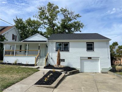 View of front of property featuring a porch and a garage | Image 1