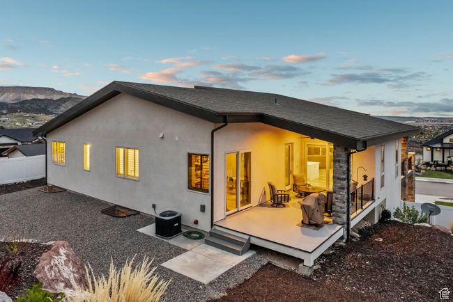 Rear view of house featuring stucco siding, fence, central AC, and a deck with mountain view | Image 84
