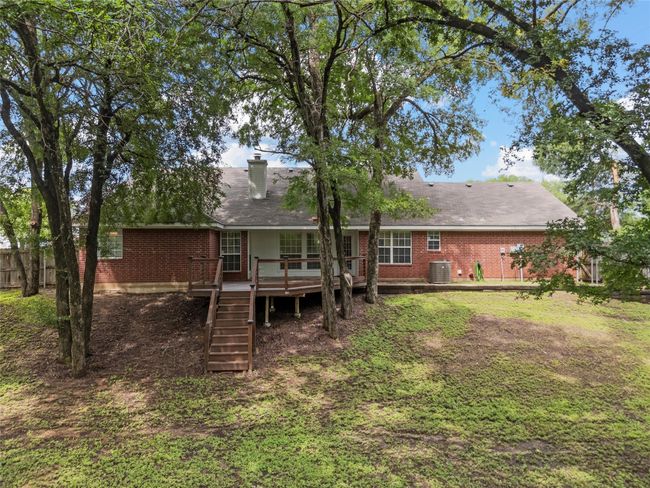 Back of property with brick siding, a deck, stairway, and a chimney | Image 18
