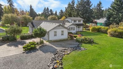 Large driveway with plenty of parking space including concrete area outside two car garage. | Image 3