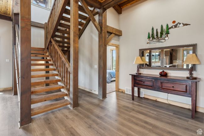 Staircase featuring a towering ceiling, wood finished floors, and baseboards | Image 40