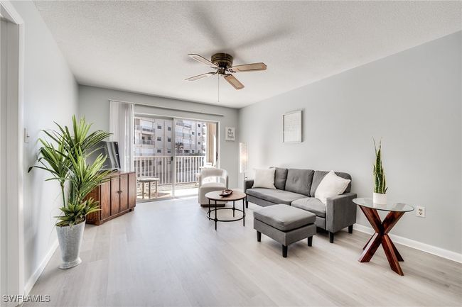 Living room featuring a textured ceiling, light hardwood / wood-style flooring, and ceiling fan | Image 22