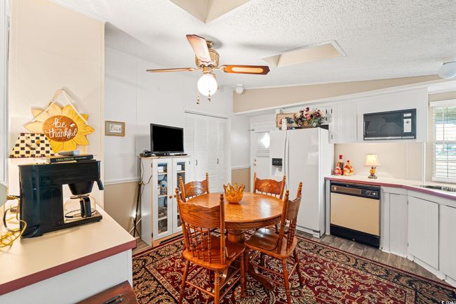 Dining space featuring a textured ceiling, light wood finished floors, and a ceiling fan | Image 20