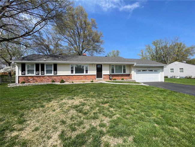 Ranch-style house featuring brick siding, an attached garage, driveway, and a front yard | Image 4