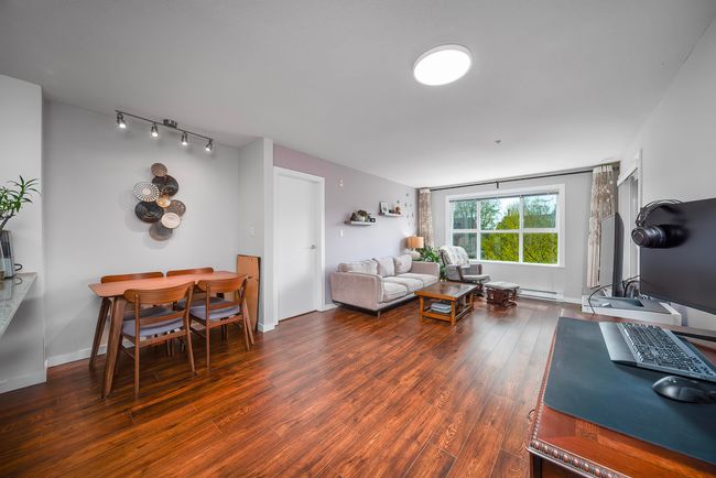 Living area featuring baseboards, a baseboard heating unit, and wood finished floors | Image 7