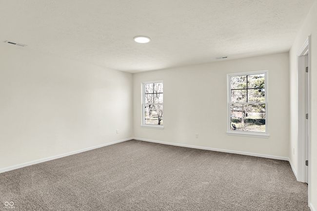 carpeted empty room featuring visible vents, baseboards, and a textured ceiling | Image 23